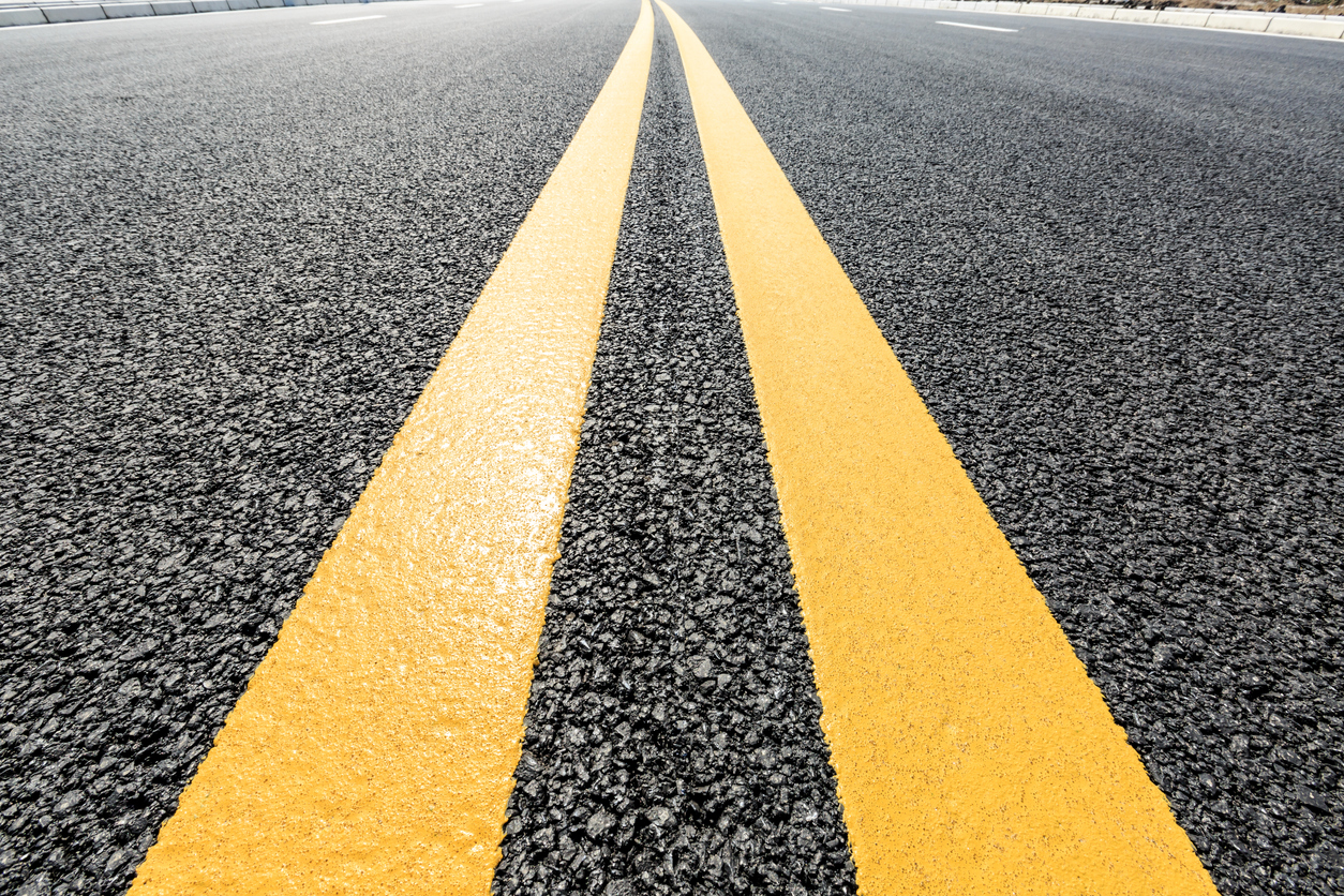 closeup of yellow lines dividing a road